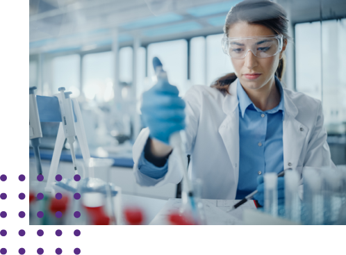 Female in lab coat working with beakers and syringe