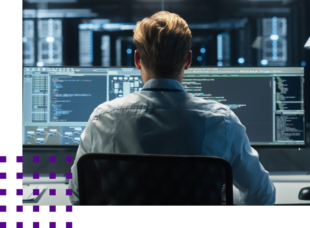 man at dual screened computer